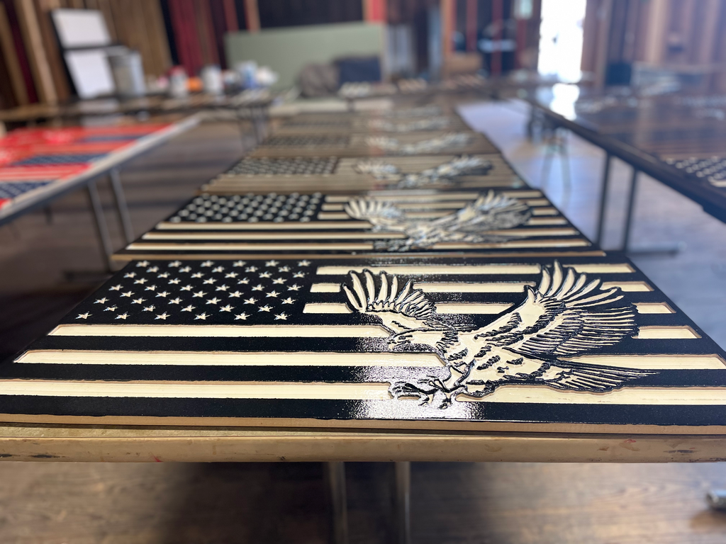 Carved wooden American Flag. This wooden flag is black & white, and it features an American Bald Eagle.