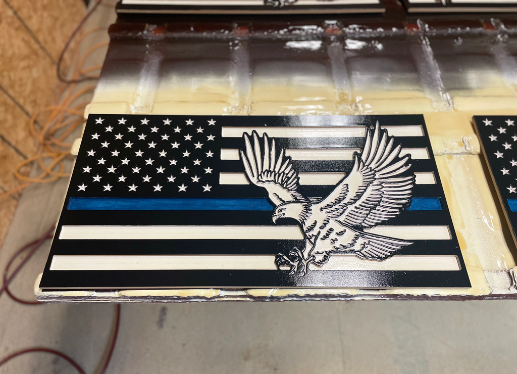 Carved wooden American Flag. The eighth stripe on this flag is blue, showing support for Law Enforcement throughout The United States. This wooden flag also features an American Bald Eagle.